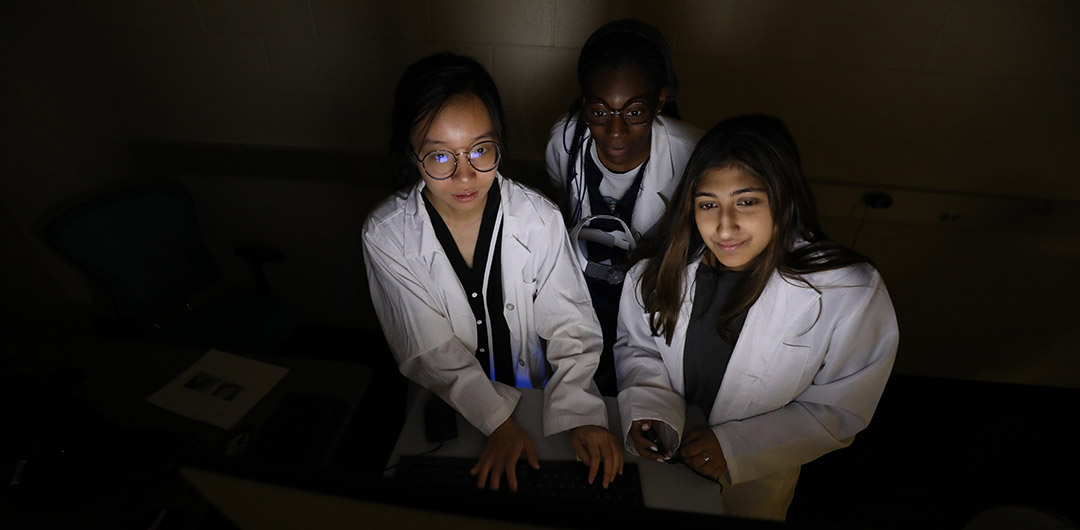 Three female students working in a lab