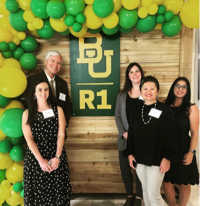 Dean Lyon and staff members with green and gold balloons